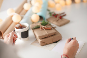 Woman sitting on the desk with christmas gift box