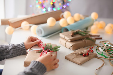 Hands of woman decorating christmas gift box