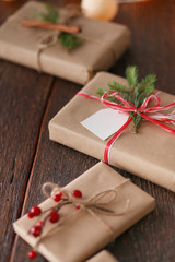 Christmas gift boxes and fir tree branch on wooden table