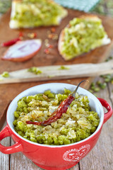 Cream of split green peas with sauce of oil and onions inside small pot and spread over bread slices.