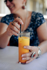 Close up on glass of fresh fruits drink over light table background. Healthy positive lifestyle
