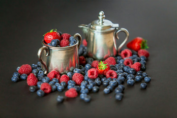 Background of raspberries, strawberry and blueberries. Berry on black background with copy space. Summer and healthy food concept, Top view or flat lay.