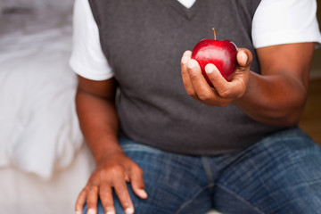 Mature man holding an apple.