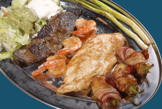 Cielo, Mar y Tierra, tocineta, guacamole y lechuga. Shirmp plate with beef  steak, chicken, bacon with guacamole and lettuce Stock Photo | Adobe Stock