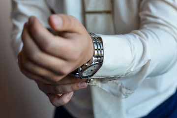 man in a tux fixing his cufflink