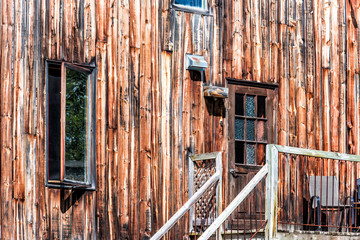 Rustic old, vintage retro wooden house, home or building with door entrance and open windows in countryside, porch