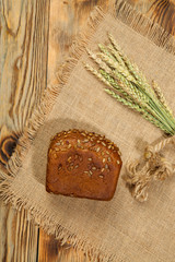 Fresh round bread on black wooden board, top view with copyspace