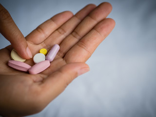 Closeup woman hand holding a pill. Healthcare, medical supplements concept