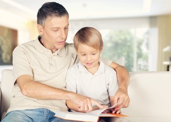 Dad and child read book.