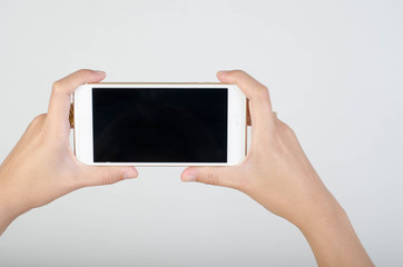 Woman hand holding smartphone with blank screen isolated on white background.