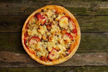 Chicken pizza on a rustic wooden table. Top view, flat lay.