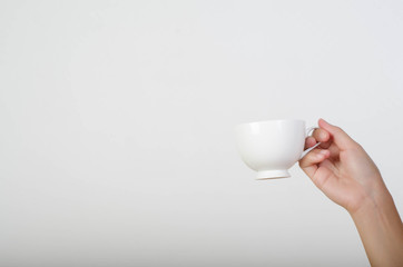 Close up of woman hand holding a cup of coffee isolated on white background.