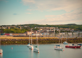 Small town on sea coast. Beautiful landscape of fishing town. Boats and yachts in Howth harbor in summer. Suburb of Dublin, Ireland. Lightly toned