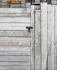Old wooden plank vertical and horizontal door with padlock.