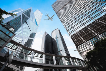 Modern buildings in central Hong Kong with airplane in the sky - obrazy, fototapety, plakaty