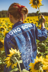 Beautiful stylish hippie girl on the sunflower field