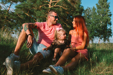Young family portrait, mother, father and daughter having fun together and hug each other