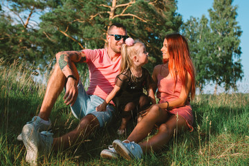 Young family portrait, mother, father and daughter having fun together and hug each other