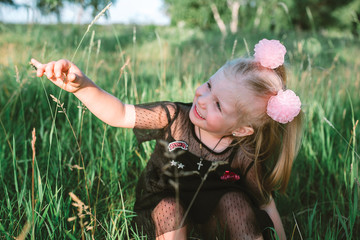 Portrait of child girl with blonde hair and blue eyes in the forest