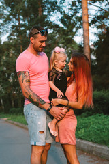Young family portrait, mother, father and daughter having fun together and hug each other
