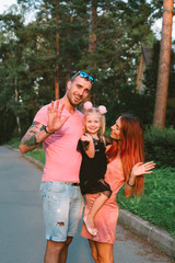 Young family portrait, mother, father and daughter having fun together and hug each other