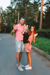 Young family portrait, mother, father and daughter having fun together and hug each other
