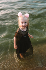 Portrait of child girl with blonde hair and blue eyes on the lake