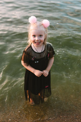 Portrait of child girl with blonde hair and blue eyes on the lake 