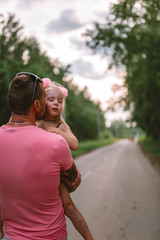Happy Father's Day! Child girl and her father having fun together, playing and kissing in the park, outdoors