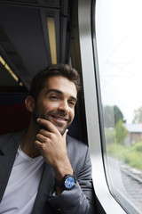 Handsome passenger in grey, smiling on train