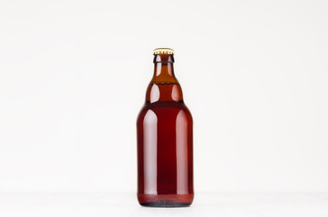 Brown steinie belgian beer bottle  330ml mock up. Template for advertising, design, branding identity on white wood table.