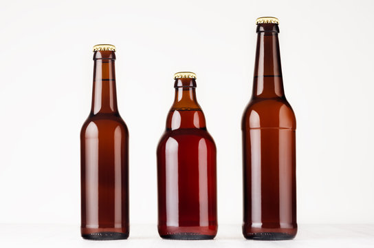 Set of different brown beer bottles  500ml and 330ml mock up. Template for advertising, design, branding identity on white wood table.