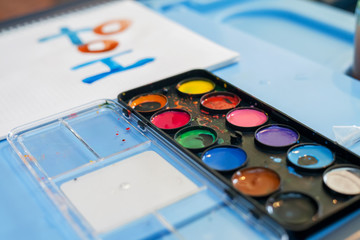 Watercolor and brushes at white background. Flat lay, top view