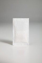 sugar sachet over gray background, close up