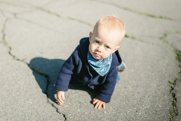 Portrait of a cute child boy with blue eyes, who is starring at the camera and smile.Outdoors healthy child activity, active lifestyle and having fun on family summer vacation with son at the playgrou