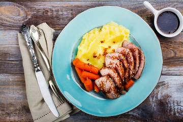 Roast veal with mashed potatoes garnish on blue plate. Copy space