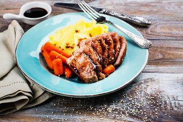 Roast veal with mashed potatoes garnish on blue plate. Copy space