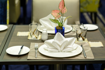 White serviette decorated on dinner set table in restaurant