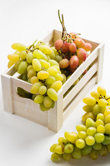 Closeup of green grapes in a wooden box on white background