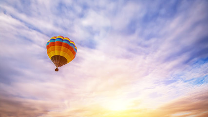 Colorful hot air balloon flying over the sky as background at sunrise