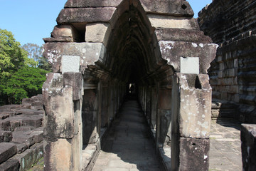 Fototapeta premium Ruins and walls of an ancient city in Angkor complex, near the ancient capital of Cambodia - Siem Reap