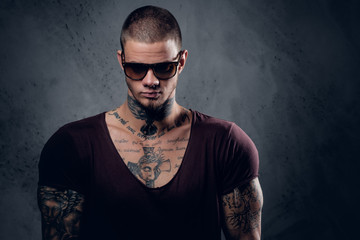 Tattooed male over grey background in a studio.