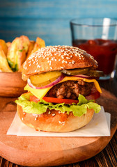 Homemade burger with fresh vegetables, tomato sauce and potatoes.