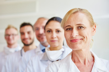 Fototapeta premium Frau als Ärztin mit Ärzteteam