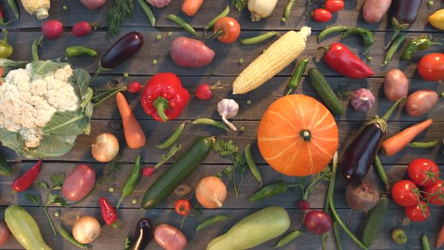 Vegetable mix on the table.

Top view. The smooth glide of the camera ( from left to right ) along the old village table with a variety of vegetables.