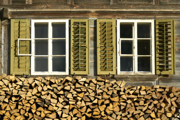 Zwei Fenster über Brennholzstapel