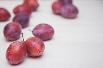 Red plum on a white table.