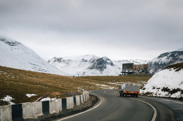 Georgian military road. The scenic winding road among mountains in Georgia. Main Caucasian Ridge and Cross Pass Gudauri and Soviet Monument to Russian Georgian Arch of Friendship of Peoples in winter