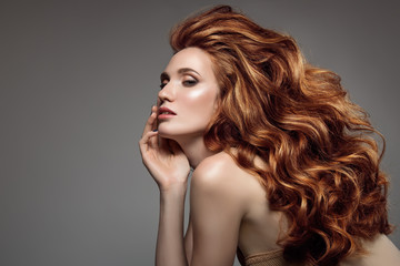 Portrait of woman with long curly beautiful ginger hair.