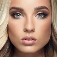 Blond woman with long curly beautiful hair. Close up face